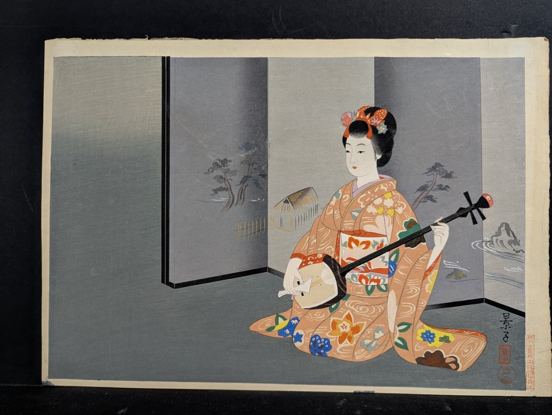 Yurimoto Keiko Woman Playing the Shamisen Japanese Woodblock Print: Experience the beauty of this exquisite Japanese Woodblock Print by Yurimoto Keiko, measuring 17 3/4 x 11 3/4 inches. This striking artwork features a beautifully attired woman engrossed in playing th