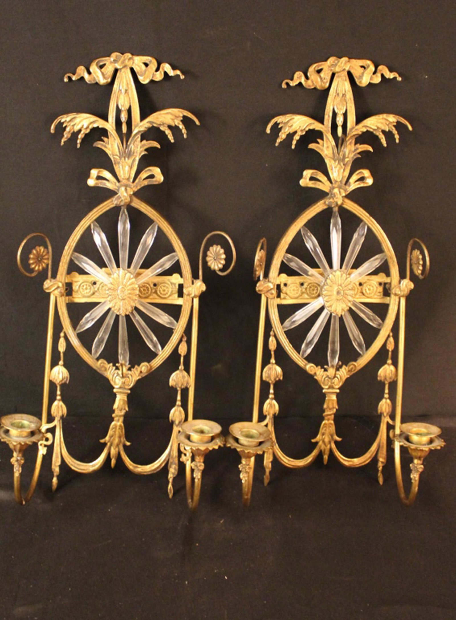Antique Neoclassical Gilt Metal Wall Sconces: Gustavian / Neoclassical style cast and gilt brass frames with center crystal prism starburst design (2 prisms missing from each sconce). Double candle arms and two hooks for missing crystal stands. G