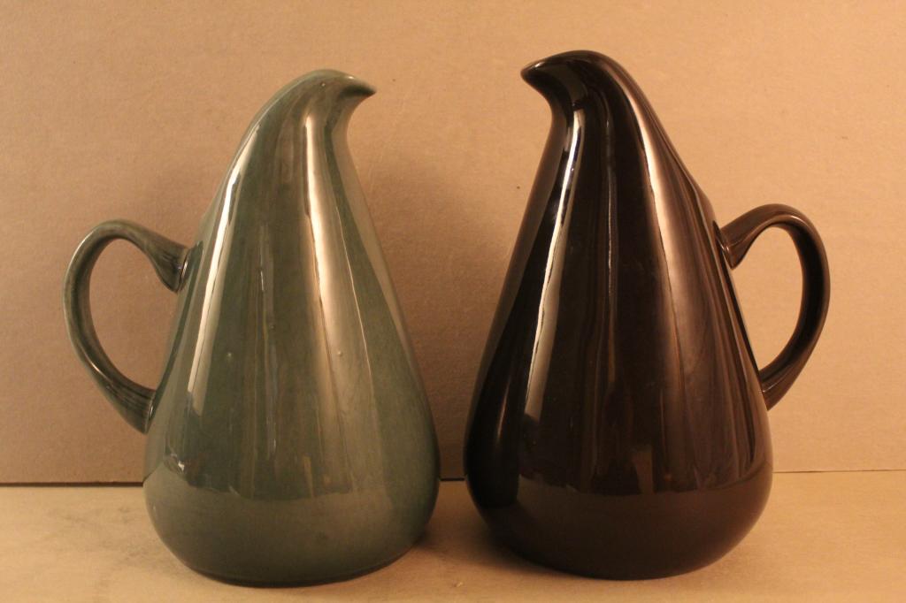 Two Russel Wright American Modern Pitchers: (1) Vintage Steubenville pitcher in green tone glaze. (2) Oneida reissue pitcher in brown glaze. 10.75" H approx. Excellent condition.