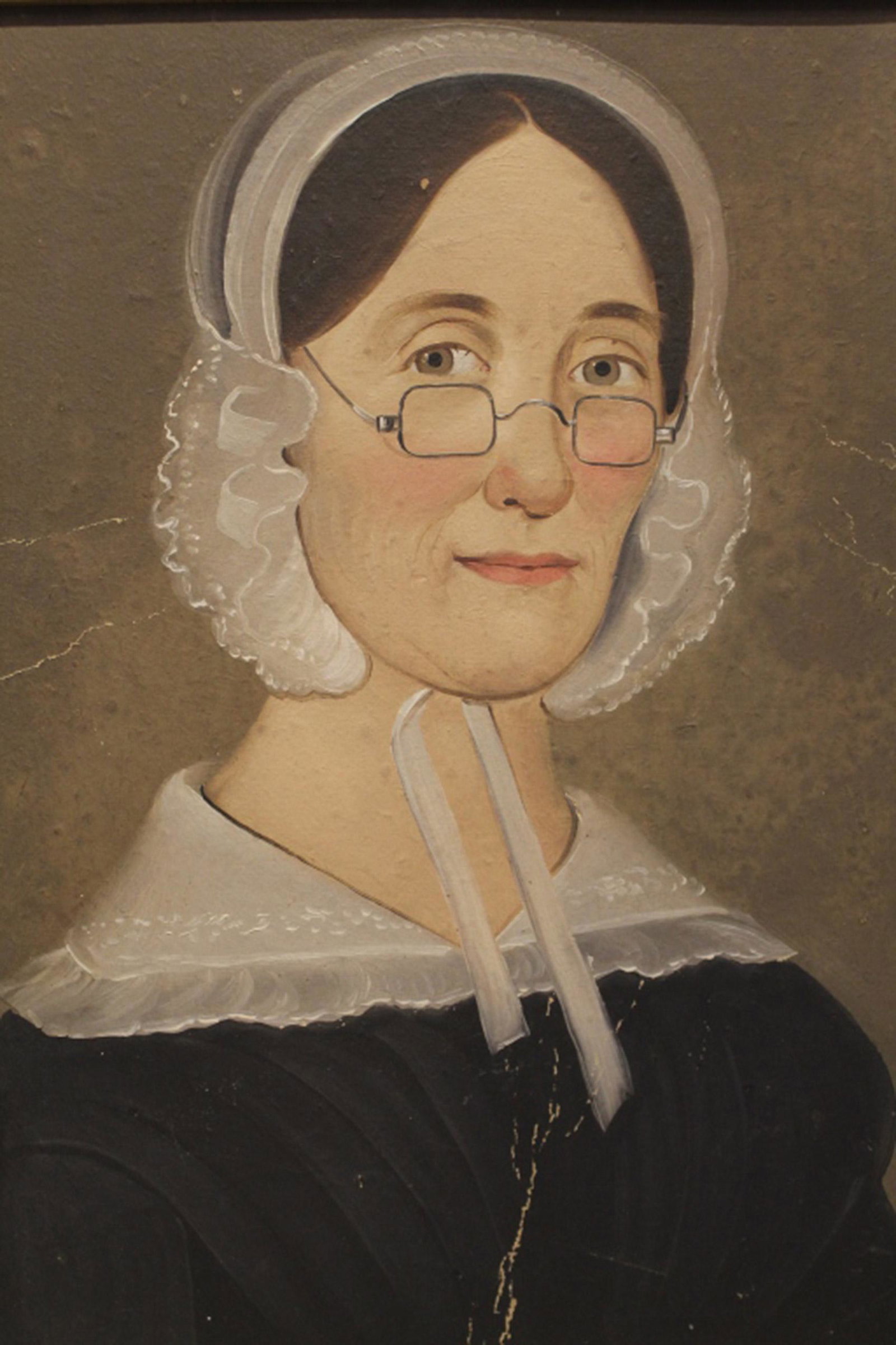 19th Century Folk Art Primitive Portrait of Woman: Antique 19th Century primitive/ folk art portrait of woman wearing glasses in period frame. Painted in tempera on artist's board; unsigned. Some areas of creasing and paint loss to the surface; surfac