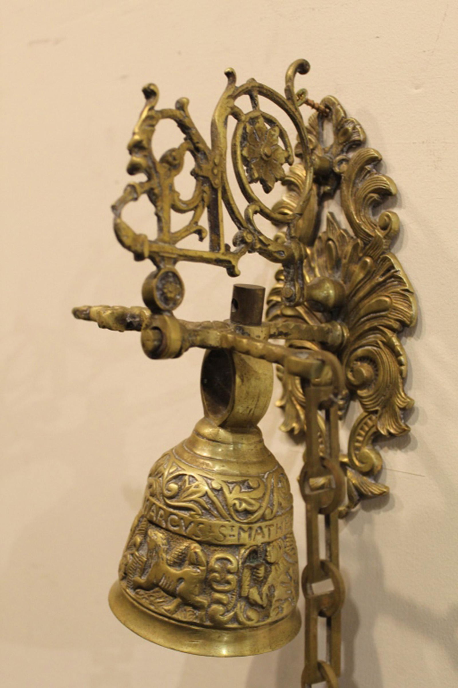 Cast Solid Brass Wall Mount Sanctuary Bell: Deeply cast relief bell with chain pull chain. Bell 4.25" x 3" dia. 21" total length approx.