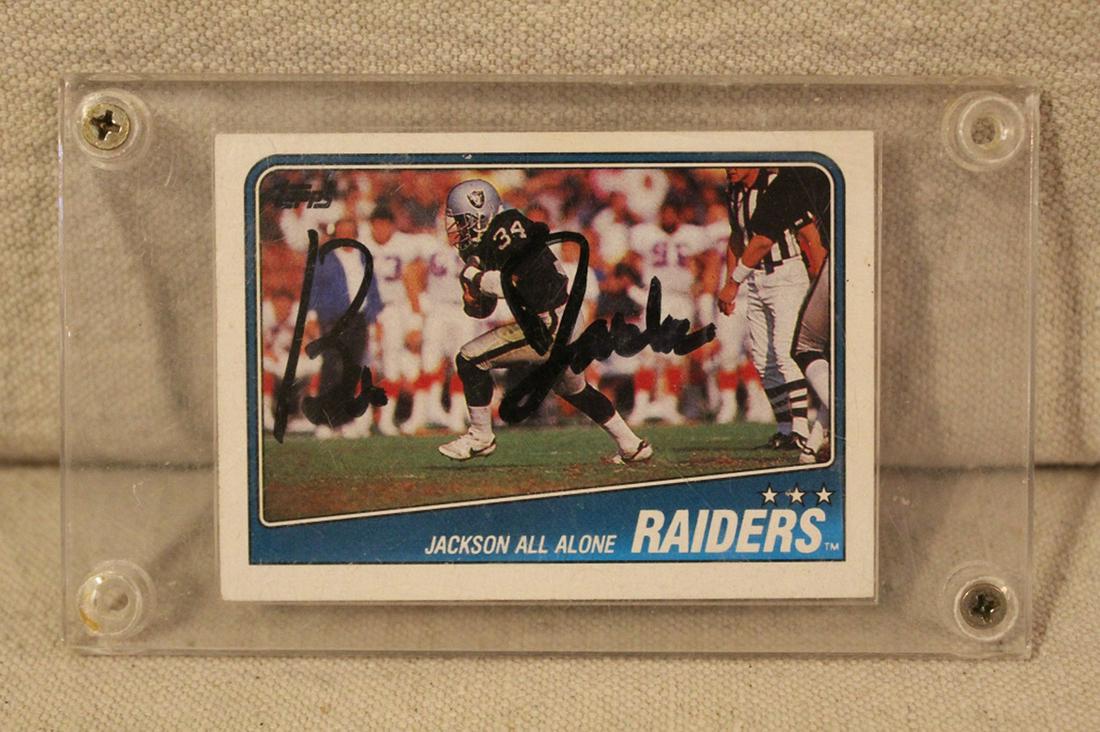 Bo Jackson Signed Raiders Jackson All Alone Footbd: 1988 Bo Jackson signed Jackson All Alone Raiders football trading card. Signed in black felt pen to front of card; enclosed in protective plastic cover. Appears to be in near mint condition. Dimension