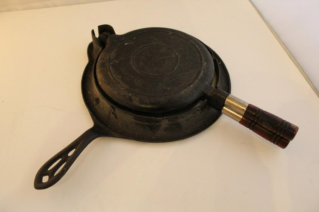 Vintage Wagner / Griswold Cast Iron Waffle Maker: (1) Wagner two piece wood handle waffle press marked #8 PAT'D FEB 22 1910 SYDNEY. (2) Marked Griswold #8 base with skillet type handle. Both good condition with signs of use.