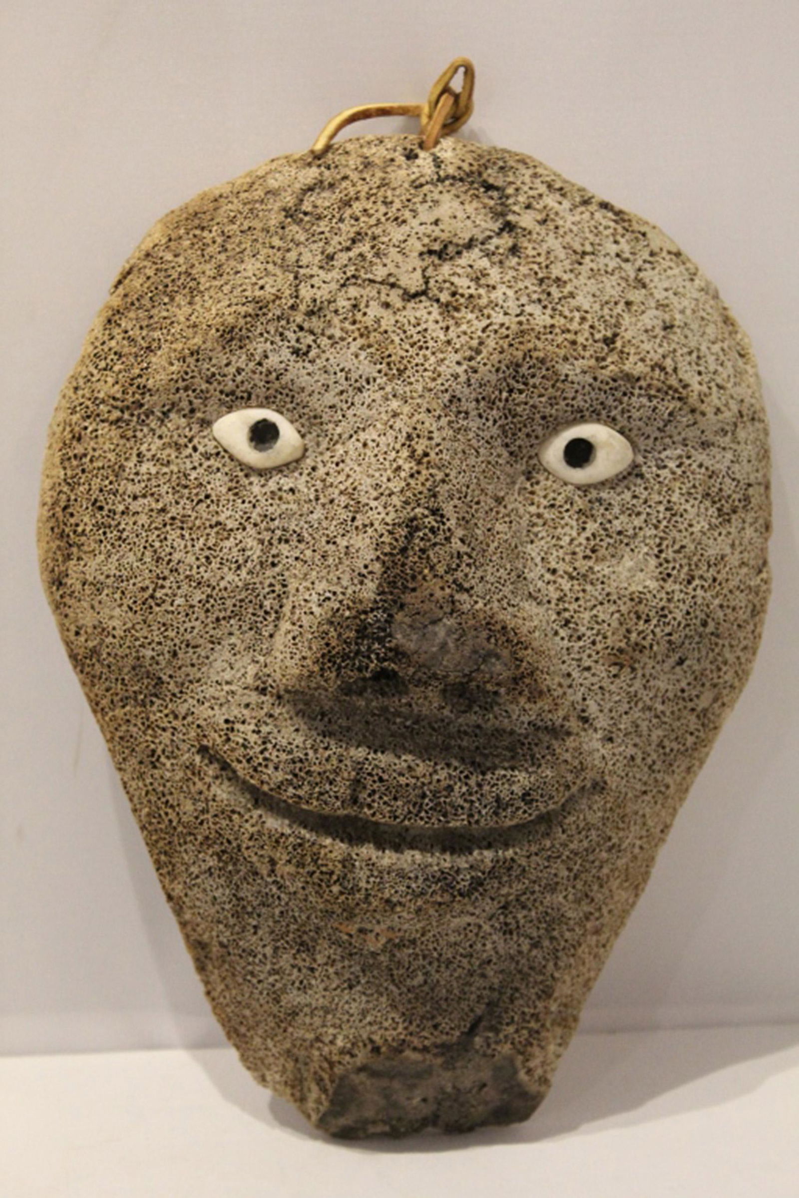 Fossilized Whale Bone Alaska Native Inuit Mask: Spirit mask in carved bone with inset shell eyes. Later added leather hanging strap. Circa mid 20th C. or earlier. No apparent signature or maker's marks. Excellent aged condition, etc. 9 5/8" x 7" W.