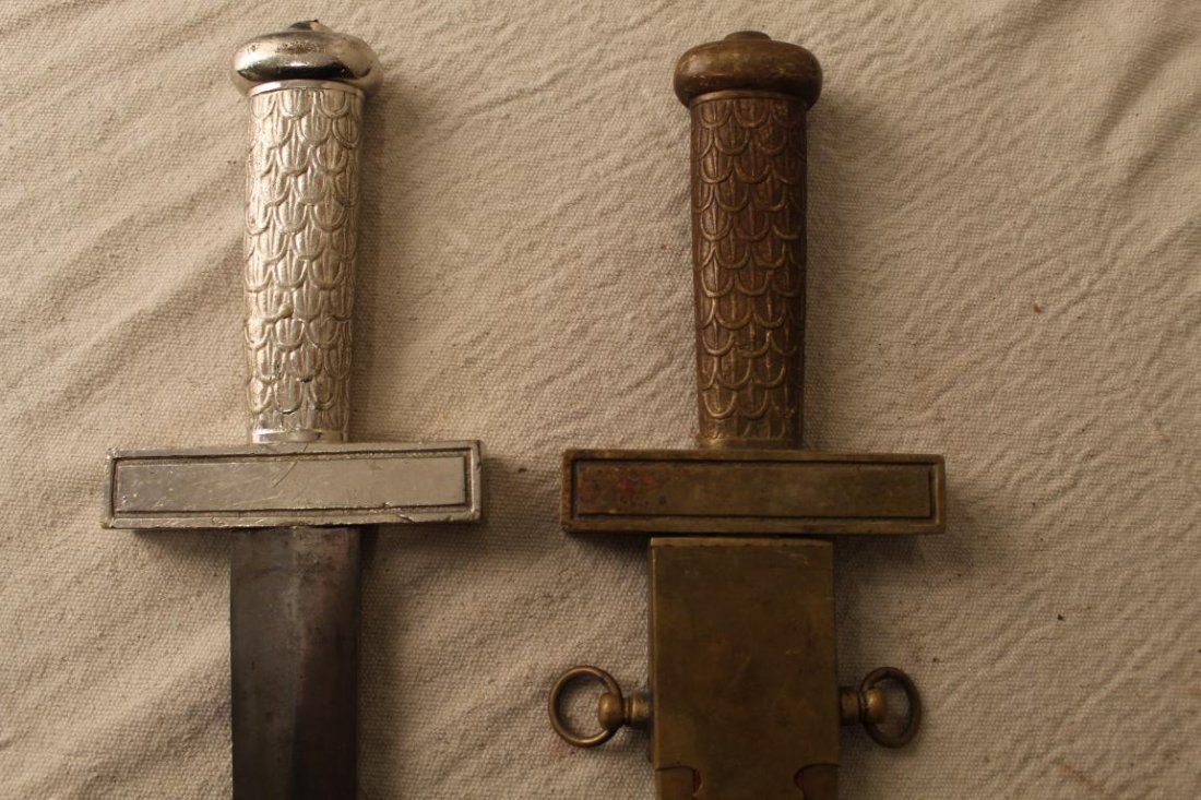 Pair Odd Fellows Ceremonial Short Swords: Pair late 19th Century Odd Fellows ceremonial short swords with decorative "feather" grips (one bronze, one nickel plated) and brass and velvet scabbard. Wear to grips; wear and areas of rust on blade