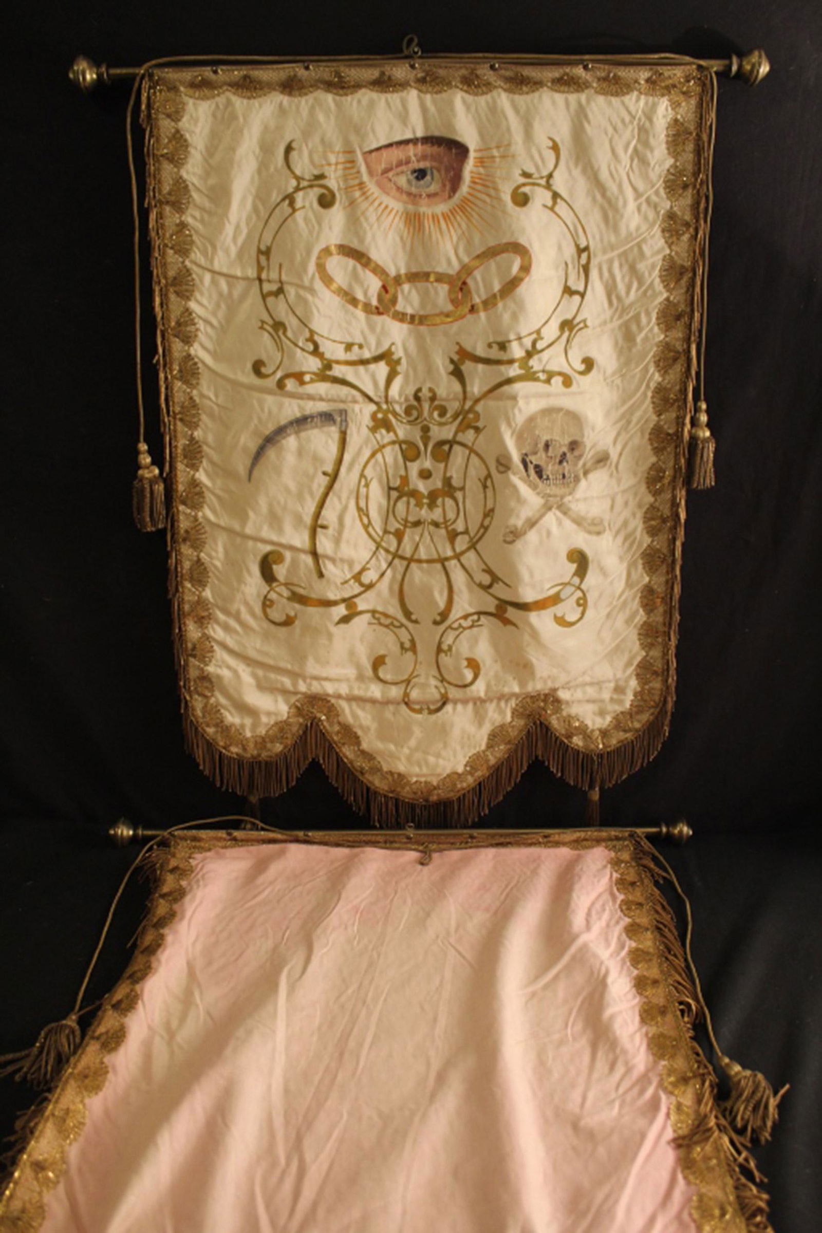Hand Painted White Silk Odd Fellows Hanging: 19th Century Odd Fellows large hand painted white silk emblematic wall hanging with gilt fringe and images of the "all seeing eye", cross bones and skulls and scythe. Mounted on brass rod with finials