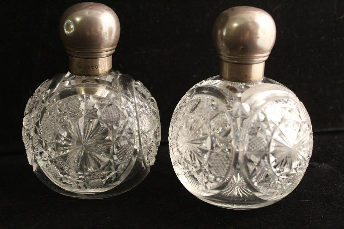 Pair English Cut Glass Sterling Perfume Bottles: Pair cut crystal perfume bottles with sterling caps; caps are marked with London date marks for 1893 and hallmarks for Mappin Brothers. Both bottles are in good overall condition with occasional "flea