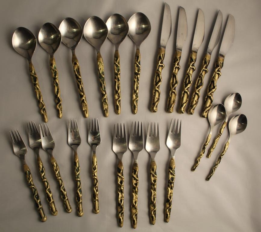 David Marshall Brutalist Bronze Flatware Pieces: 1970's. Cast bronze handles with stainless steel. Includes 4 dinner forks, 5 salad forks, 5 dinner knives (blades marked Marshall), 6 table spoons, and 3 teaspoons. Alll good condition with light sign