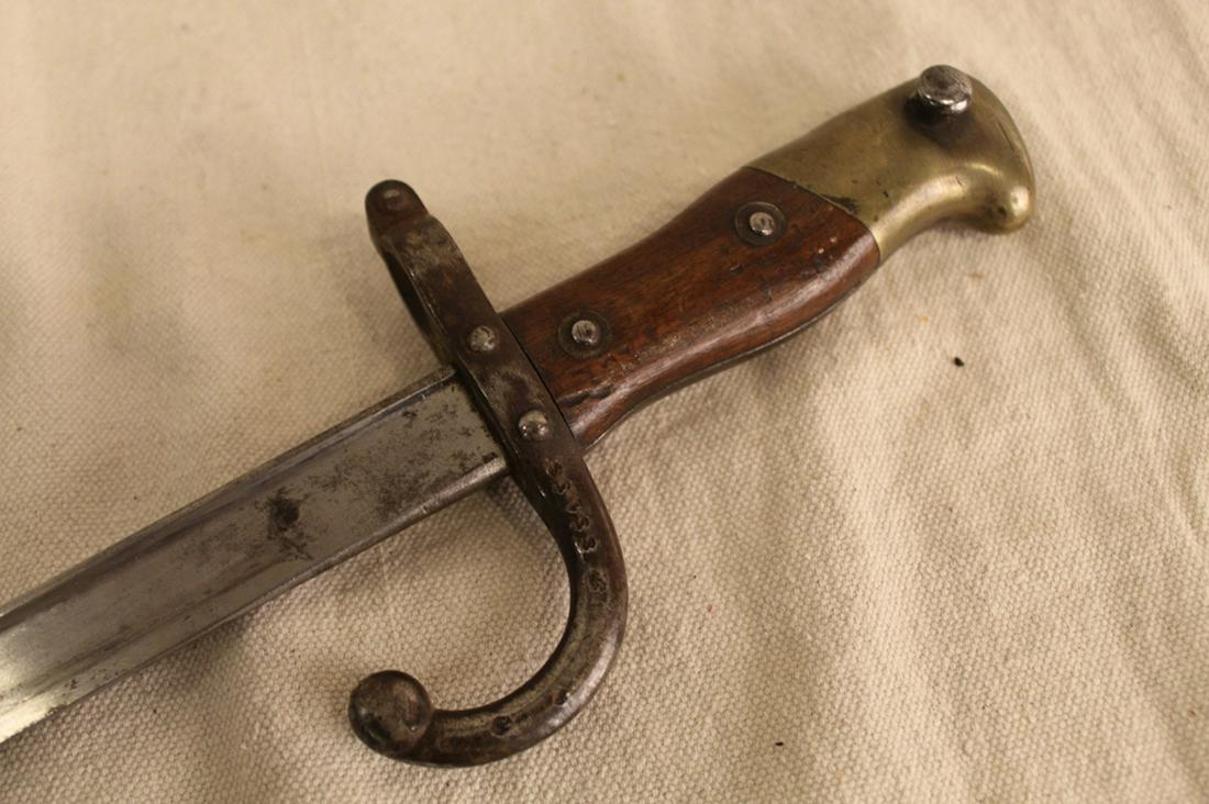 French 1879 "Gras" Sword Lebel Rifle Bayonet: 1879 "Gras" sword/ Lebel rifle bayonet with brass pommel, wood grip, and manufacturer's mark on back side of blade Mre d' Armes de St. Etienne F'bre 1879. Guard ans blade with French hallmarks and mat