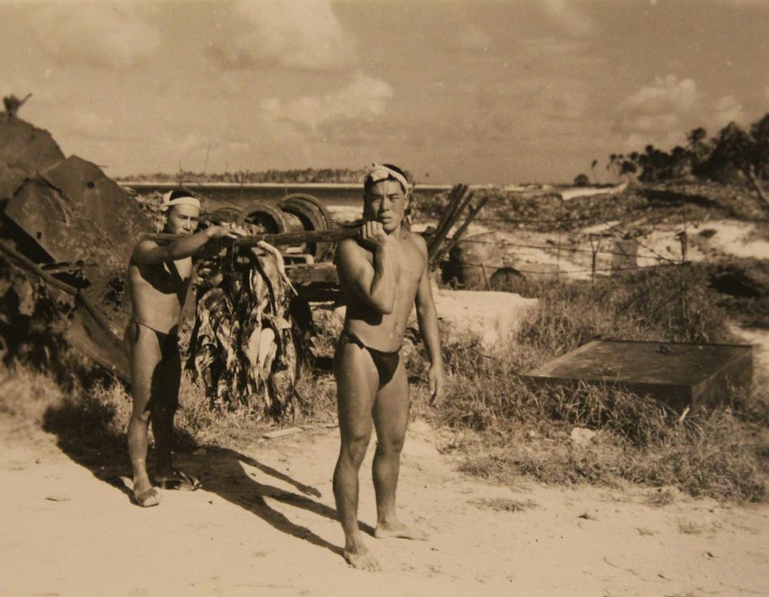 Vintage Photographs of Shirtless Men: Group of 7. Includes Japanese men on the beach carrying fish, man in bathing suit flexing dated 1937, military men, man posed on a log, and snapsots of buddies. All early/ mid 20th C. Largest 4 1/2" x