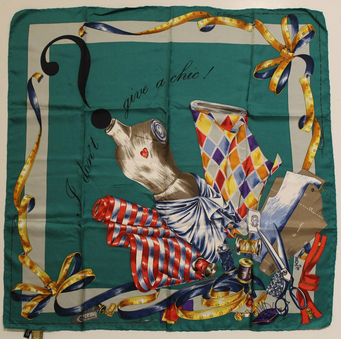 Moschino Silk Scarf: "I Don't Give a Chic". Hand rolled and stitched edges. Original Made in Itay labels. Very good condition with no apparent snags, pulls, damage, etc. 33.5" x 33" approx.