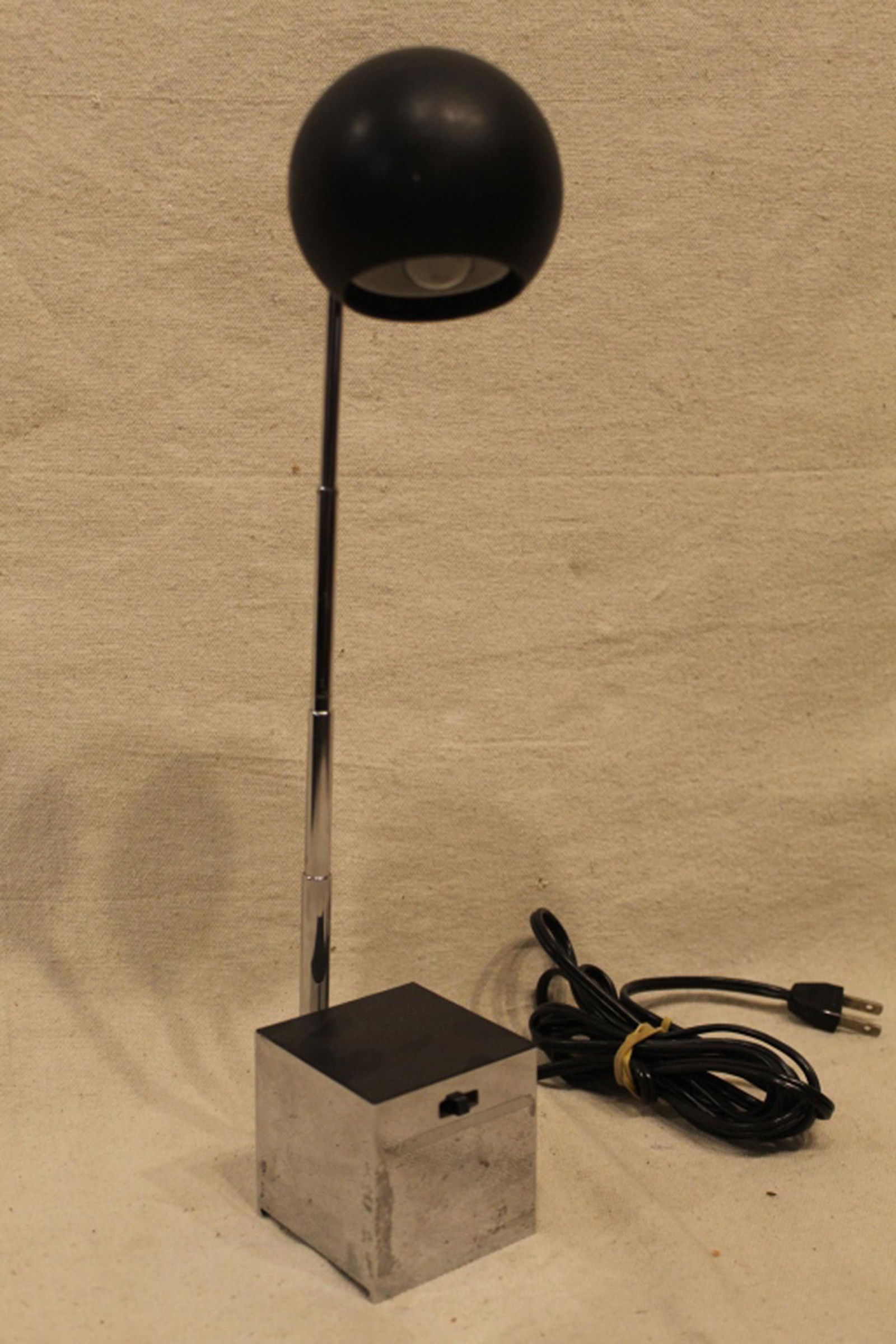 Lightolier Lytegem Task / Desk Lamp: Designed by Michael Lax. Chromed cube base (excellent condition) with black laminate top. Black ball shade (some surface marks, scuffs, etc) with telescoping neck. Working condition with high and low