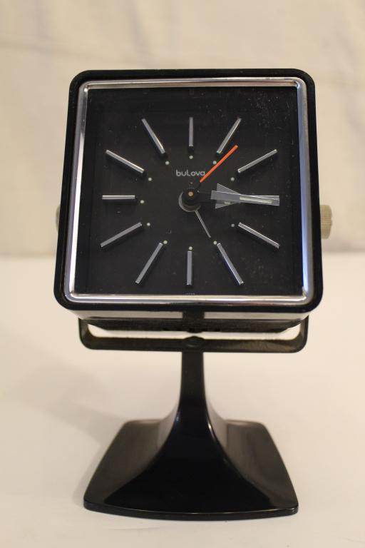Mid Century Mod Bulova Cube Alarm Clock: Black plastic tiltng cube clock mounted to tulip style base. Very good original condition. Working. Circa 1960's/ 70's. 7" H; cube 4" x 4" x 3 5/8".