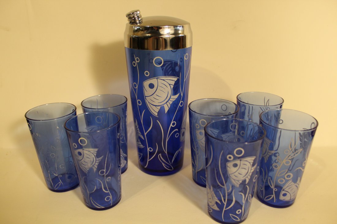Hazel Atlas Cobalt Glass Cocktail Shaker and Tumblers: Includes Hazel Atlas 9" cocktail shaker with chrome lid and screw cap, and 7 fish design tumblers (4 1/2"). Design markedly faded to 3 tumblers; the remainder in good to fair condition.