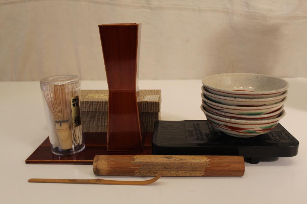 Vintage Japanese Tea Ceremony Items: Includes: Shunkei lacquer ware vase with stand (with original box), bamboo tea scoop with container, 5 matching pottery bowls (5" dia.), whisk in case, and wood stand with carved panels of calligraphy