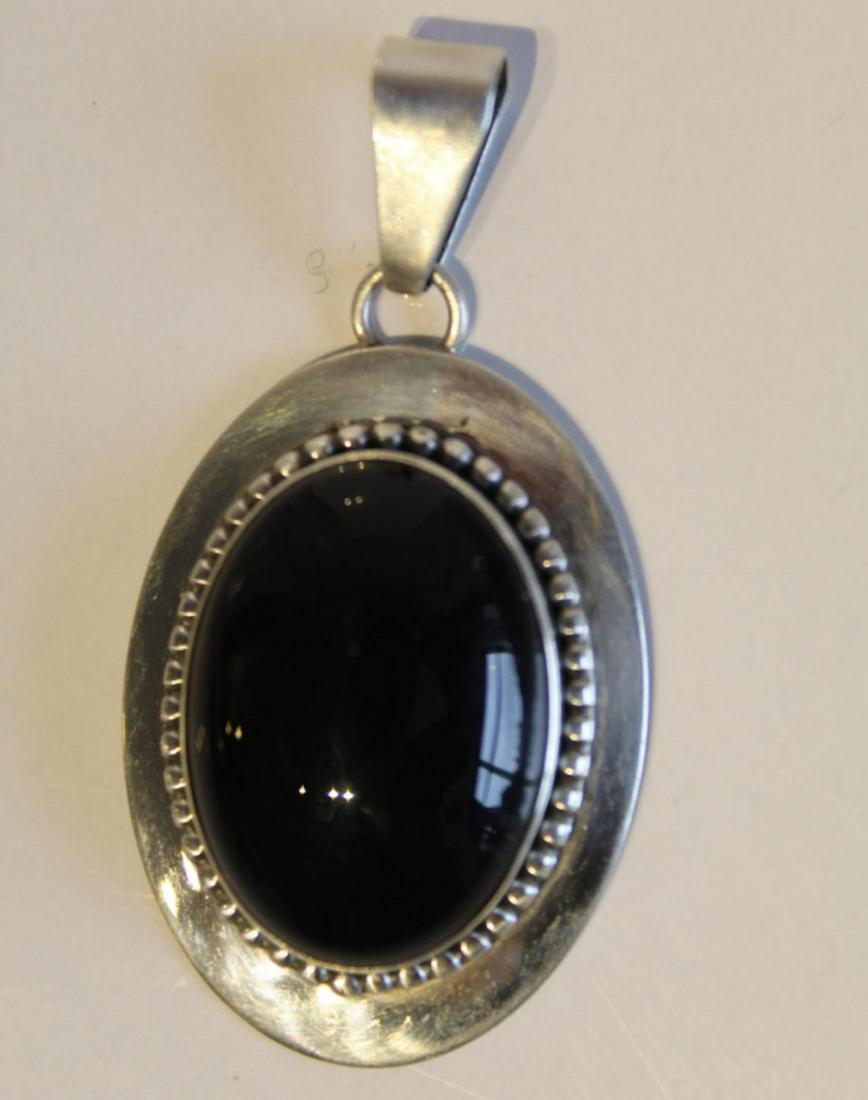 Ella Peter Navajo Stering & Onyx Pendant: Black onyx cabochon in sterling mount. Marked Ella Peter STERLING. 2" length including bail.