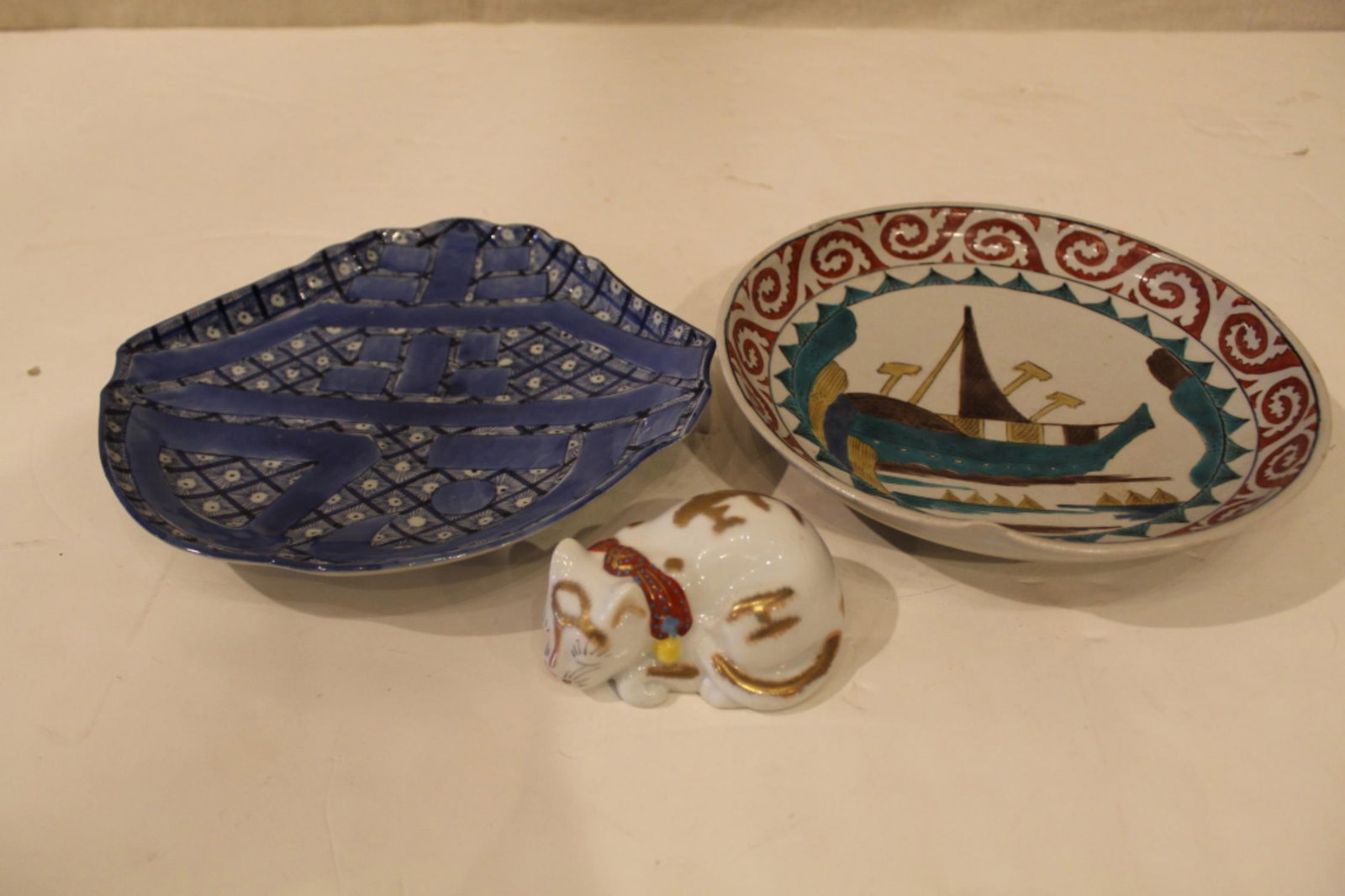 Japanese Imarai Kutani Porcelain Dish Bowl & Cat: (1) Blue and white character form dish with raised lettering. Unmarked. Good condition (small glaze flake chip at one corner point). Circa early 20th C. 9.75" x 9.75". (2) Plate with stylized boat mot