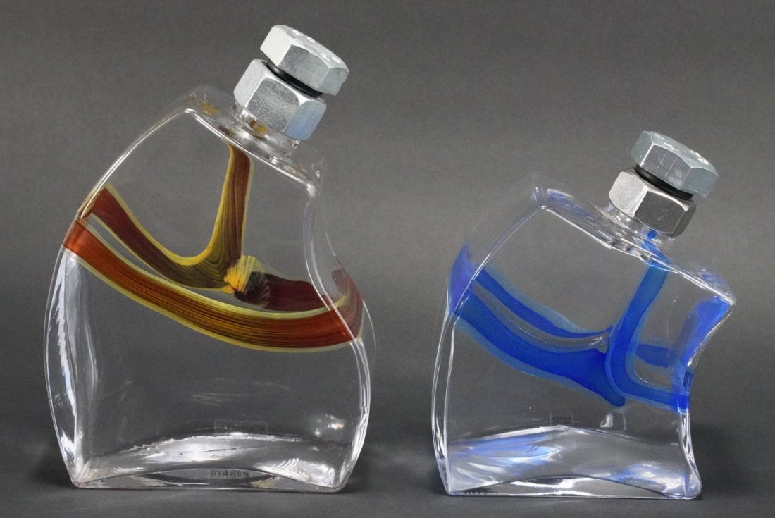Kosta Boda Macho Decanters by Kjell Engman: (1) Blue stripe decanter with original Kosta Boda lable. Etched Kosta Boda K Engman 70800/0 to bottom. Excellent like new condition. 6.5" H approx. (2) Red stripe decanter with original Kosta Boda lab