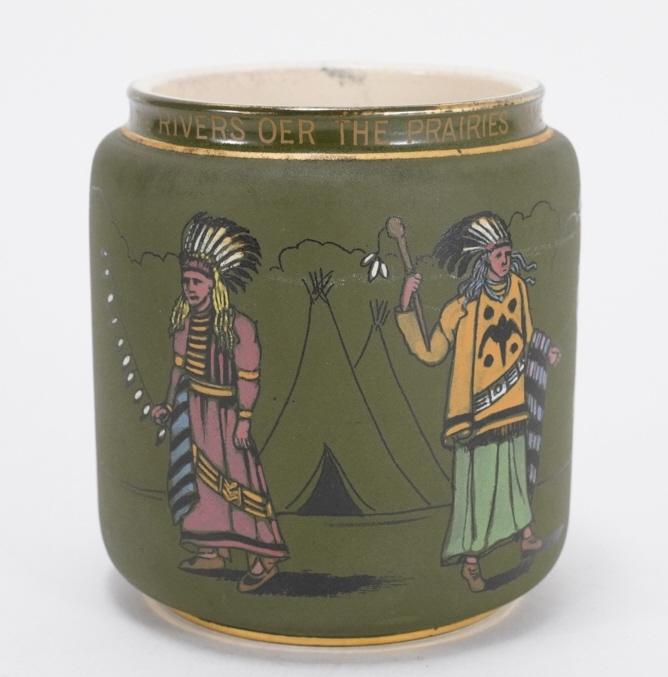 Arts & Crafts Hiawatha / Longfellow Pottery Jar: Tobacco humidor jar in mat green glaze with hand enameled figures of Native Americans. Rim with "Down the Rivers Oer the Prairies Came the Warriors of the Nations" from Longfellow's "The Song of Hiawa
