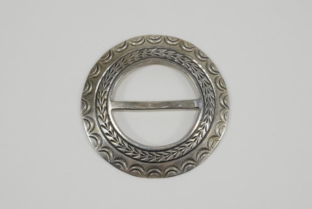 Robert Johnson Navajo Sterling Sash Buckle: hand hammered sterling sash slide buckle by Robert Johnson. Stamped STERLING RJ. 23 grams approx. 2 1/2" dia.