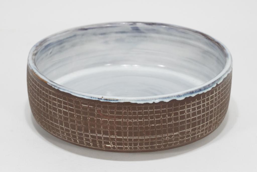 Ralph & Lorene Spencer Northwest Pottery Bowl: Unglazed exterior with incised grid decoration; interior with swirled white gloss glaze. Signed Spencer to bottom along with number 6. Excellent condition. 2.75" H x 8.75" dia.