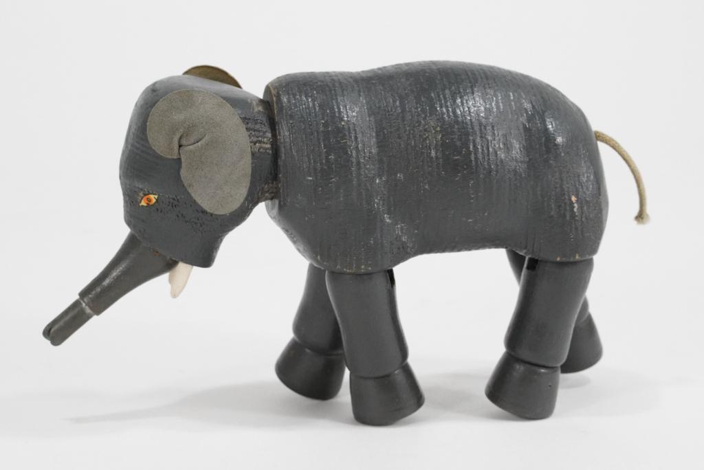 Schoenhut Humpty Dumpty Circus Toy Elephant: "The Humpty Dumpty Circus" articulated toy elephant figure. Appears in very good original condition with painted eyes, leather ears, cord tail, plastic tip to trunk, and wood dowel tusks. 4.5" H x 7"