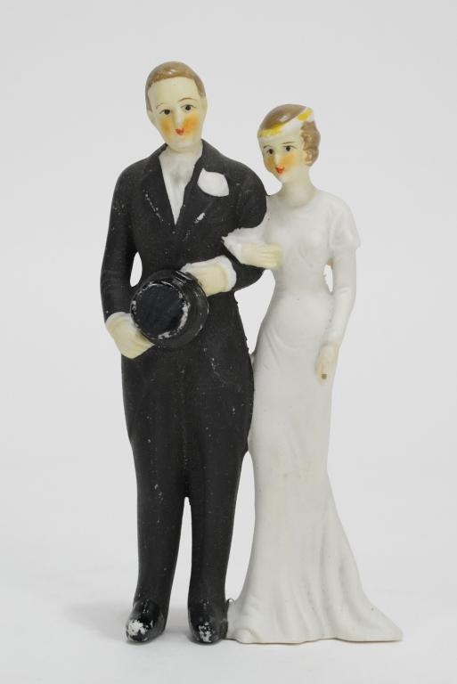 1930s Bisque Wedding Cake Topper: Bride and groom holding top hat. Hand painted. Good condition; minor paint wear, etc. No chips, breaks, etc. 6.5" H.