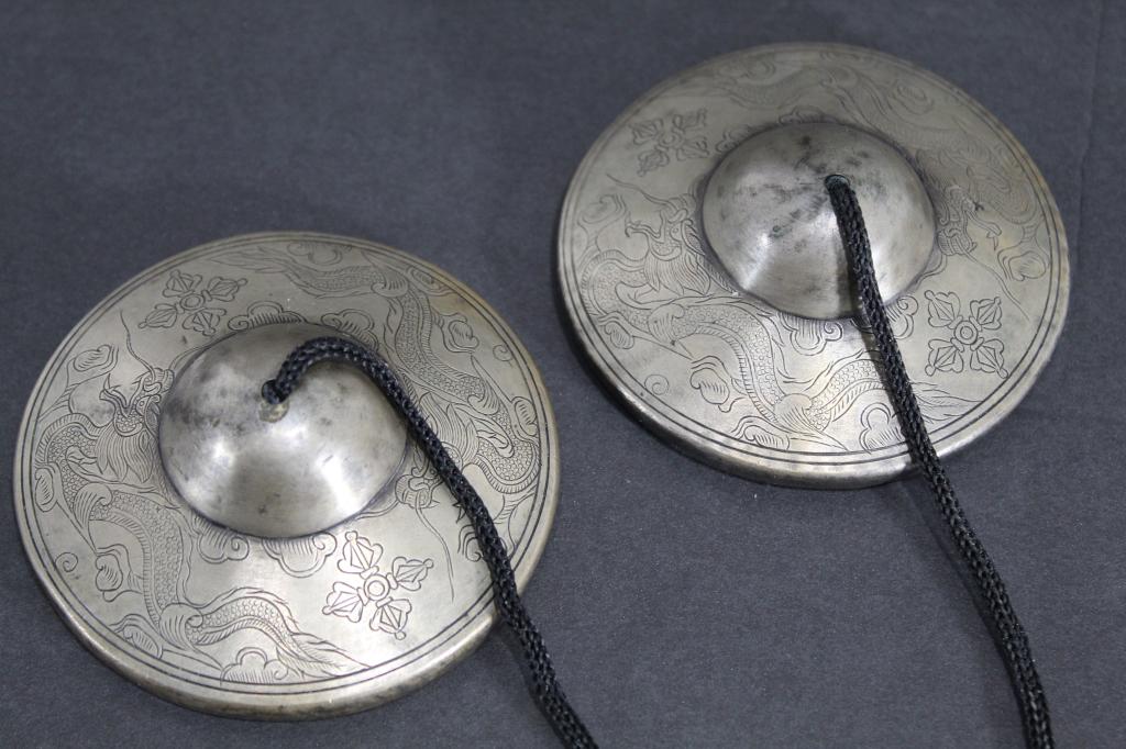 Antique Tibetan Buddhist Tingsha Cymbals: Heavy white bronze with intricate hand etched double dorje and dragon designs to tops; engraved dore designs to undersides. Clear and long sound when rung. Excellent condition with good patina. Replac