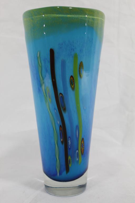 Murano Style Art Glass Vase: Clear glass over blue glass with stretched canes and millefiori. White interior. No apparent signature or marks. Good condition. 11 3/8" H x 5 1/4" lip dia.