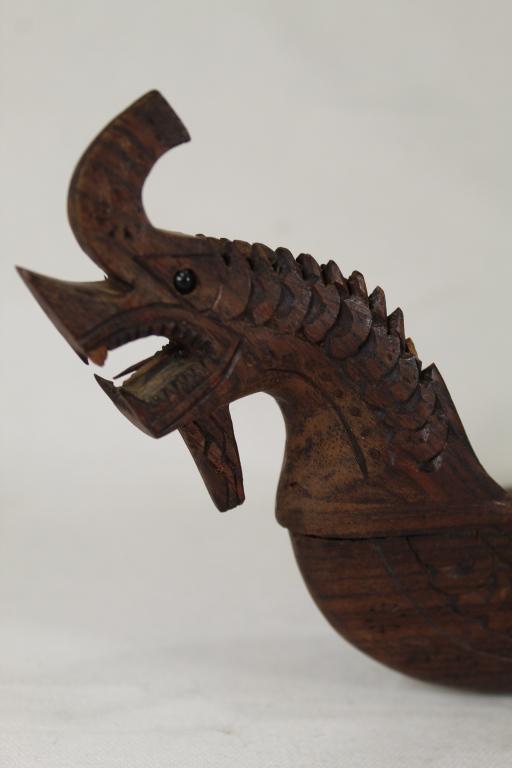 Vintage Indonesian Balinese Carved Model Boat: Well detailed hand carved rosewood model boat / canoe. Includes two model paddles. Very good condition; dragon figure head with small chip at one tooth and at one neck spike. 5" H x 16.75" L.