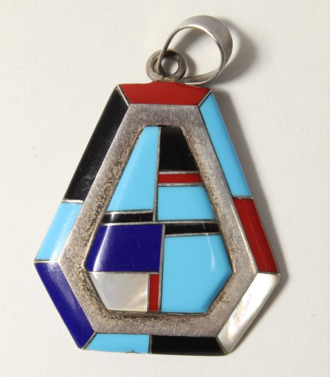 Zuni Sterling Inlaid Pendant Signed LD: Sterling with hand inlaid and polished lapis, turquoise, obsidian, carnelian, and mother of pearl. Stamped LD STERLING. 6 grams total weight approx. 1 3/4" (including bail) x 1 1/4" approx.