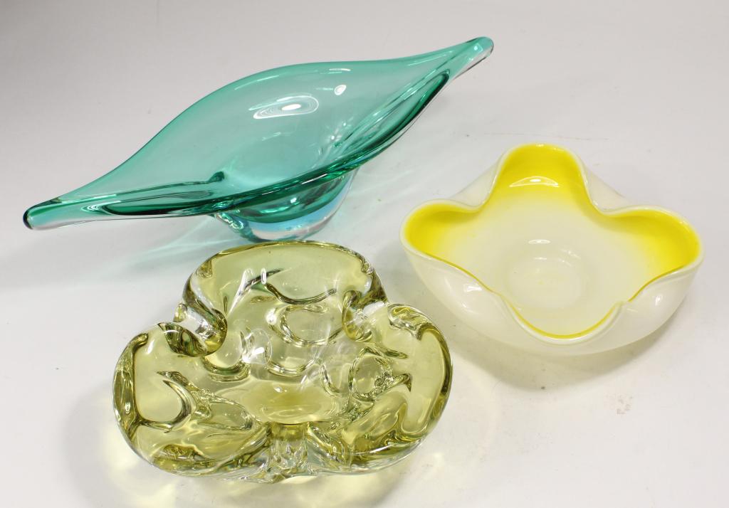 Mid Century Murano Glass Bowls: (1) Gondola style bowl in pale green glass with clear base. 3.25" H x 12.25" x 4.5". (2) Pale yellow ashtray / bowl. 2.25" H x 6.5" dia. approx. (3) White and yellow bowl. 1.75" H x 6.75" x 6". All ex