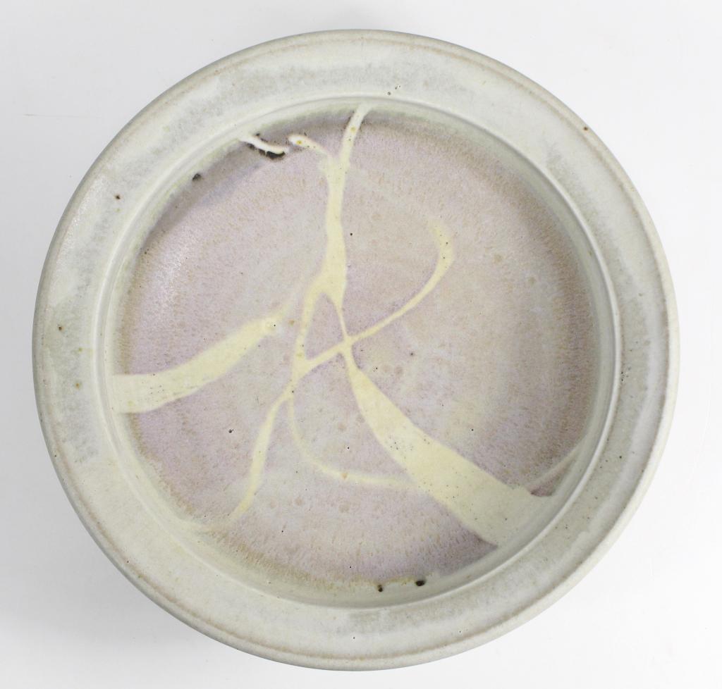 David Shaner (1934-2002) Studio Art Pottery Bowl: Satin matte glazed rimmed bowl on raised unglazed foot. Incised signature and stamp mark to bottom. Excellent condition. 3" H x 10 3/8" dia. approx. Shaner was director of the Archie Bray Foundation i