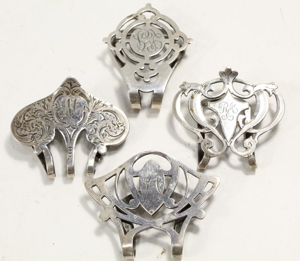 Collection Victorian Sterling Napkin Clips: Collection of 4 Victorian sterling napkin clips in various designs. All with engraved initials. 42 total grams approx. 1.5" x 1.75" approx.