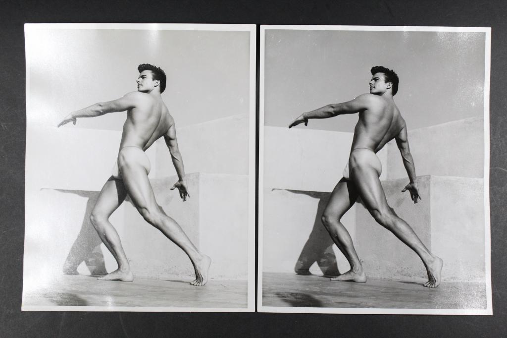 Bob Mizer AMG Male Nude Photographs: Two photographs of the same image depicting a nude male model posed against a stucco wall. Both with hand written "XGII-H" in pencil to the backs. Clear sharp silver gelatin prints on satin heavy fibe