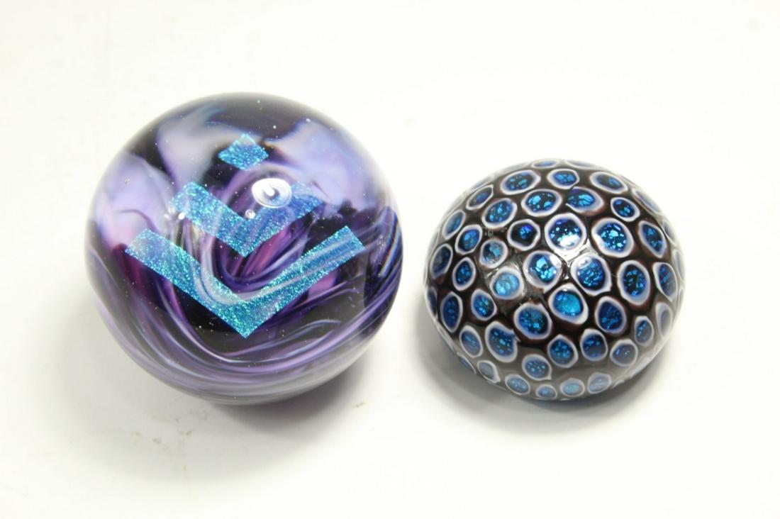 Iridescent Art Glass Paperweights: (1) Halographic arrow paperweight stamped EV and 2019. 2.75" dia. (2) Iridescent silver blue spot paperwieght, unsigned. 1.75" H x 2.5"dia.