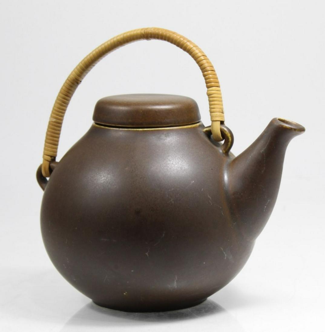 Arabia Finland Teapot by Ulla Procope: Matte brown glaze with bamboo wrapped swing handle. Arabia mark to bottom. Some light glaze scuffs and small glaze flaw to one side. 8.25" H (at handle) x 8.5" approx.