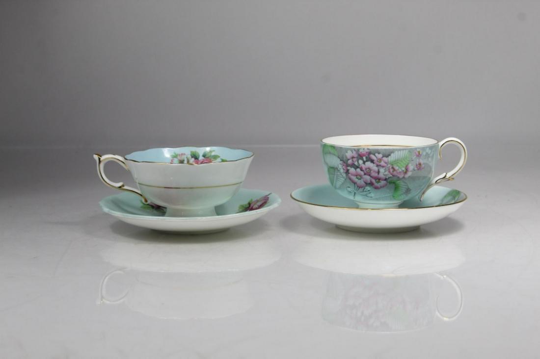 Paragon Bone China Tea Cups & Saucers: (1) Floral tea cup & saucer in pale green glaze. Double warrant marks (The Queen & Queen Mary). Cup 3 7/8" dia. Saucer 5 1/2" dia. (2) "Primula" in pale blue glaze. Circa 1930's warrant mark. Cup 3 5/