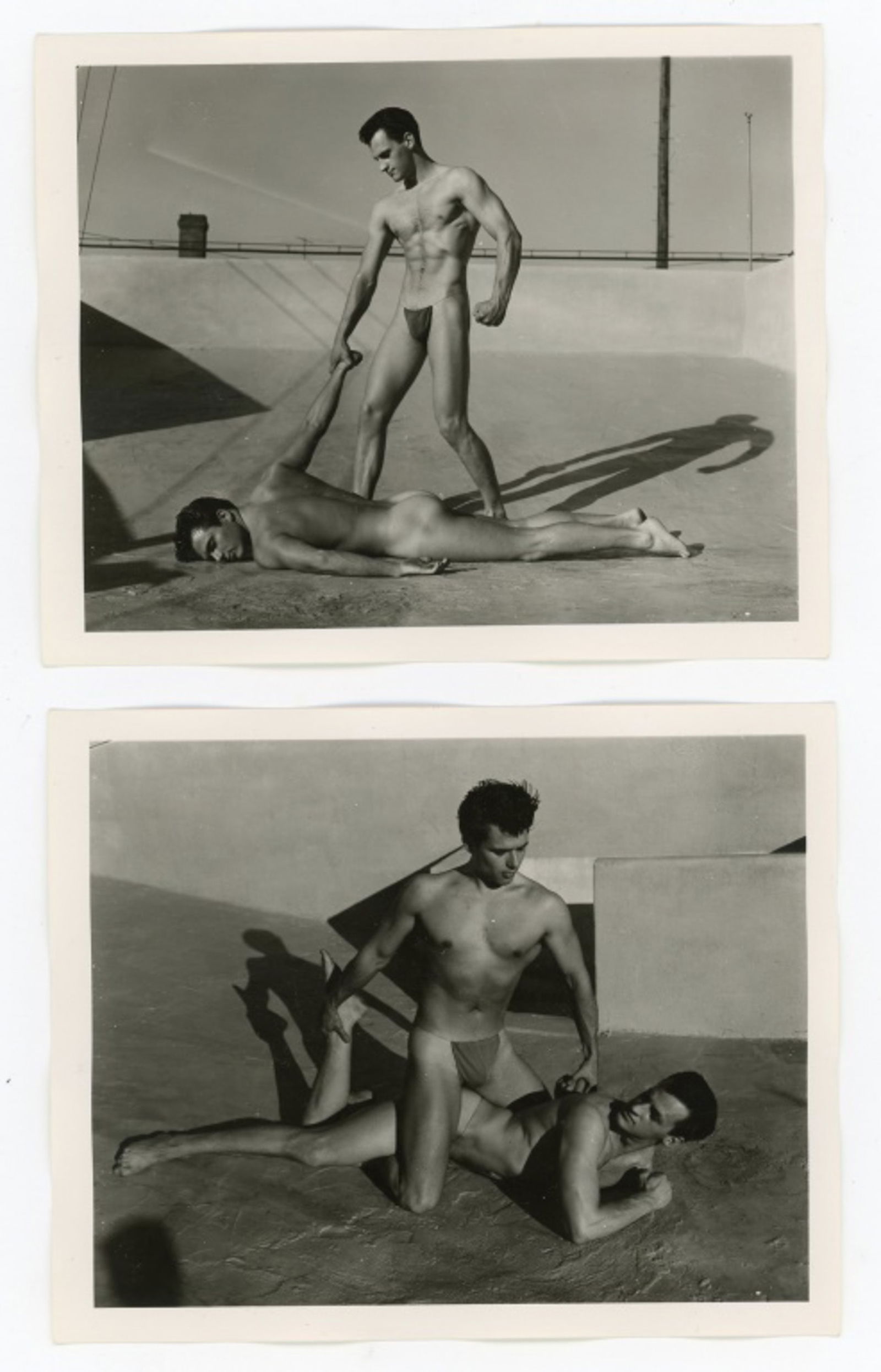 Vintage Bob Mizer AMG Male Physique Photographs: Two semigloss 4" x 5" photographs of two male models wearing posing straps on the AMG studio rooftop. Stamped 003R and 017R to the backs; one dated Febr.1956. Good condition. From the estate of model