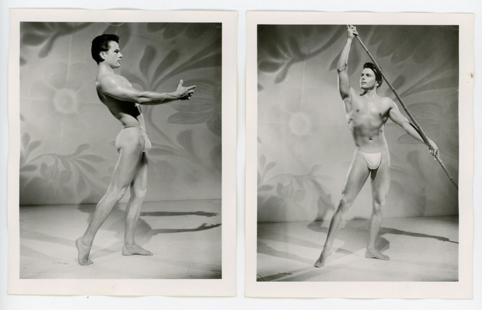 Vintage Bob Mizer AMG Male Physique Photographs: Two semigloss 4" x 5" photographs of male model wearing posing strap in studio with projected mod background. Pencil numbered 6 and 9 to the backs along with partial numbered stamps. Good condition. F