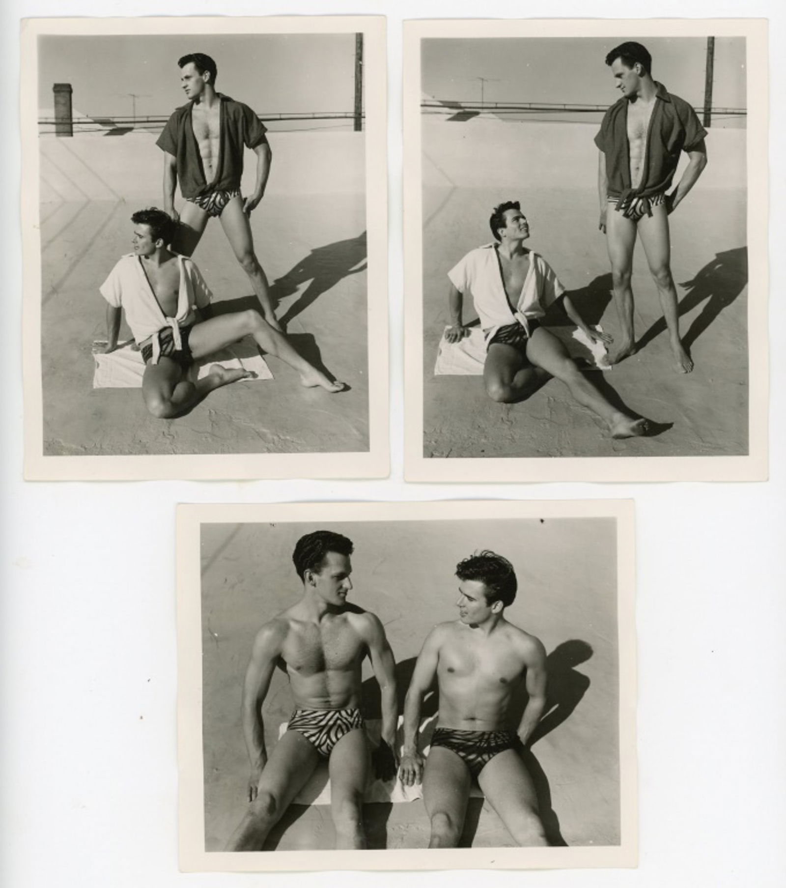 Vintage Bob Mizer AMG Male Physique Photographs: Three semigloss 4" x 5" photographs of two male models wearing striped bathing suits posed on the AMG studio rooftop. Pencil numbered 1, 2, and 5 with Feb 56 dates to the backs; one with "only one" no