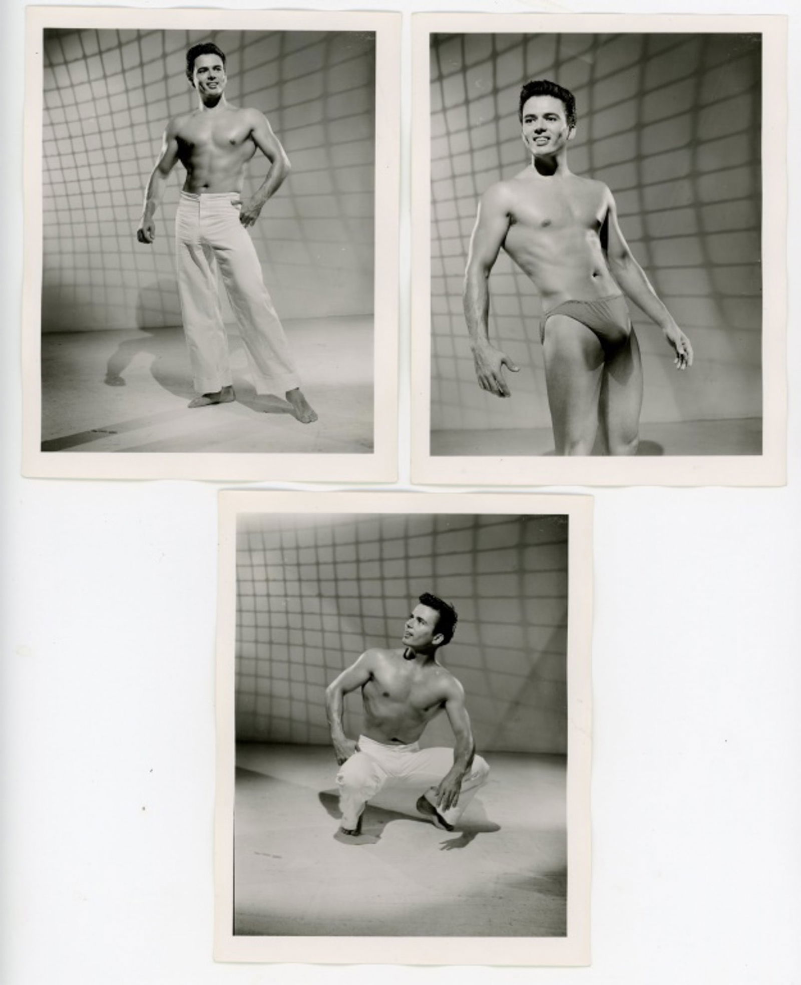 Vintage Bob Mizer AMG Male Physique Photographs: Three semigloss 4" x 5" photographs of male model posed in studio with projected netting background. Pencil numbered 4, 11, and 17 to the backs along with partial numbered stamps; one dated AUG 56. Go