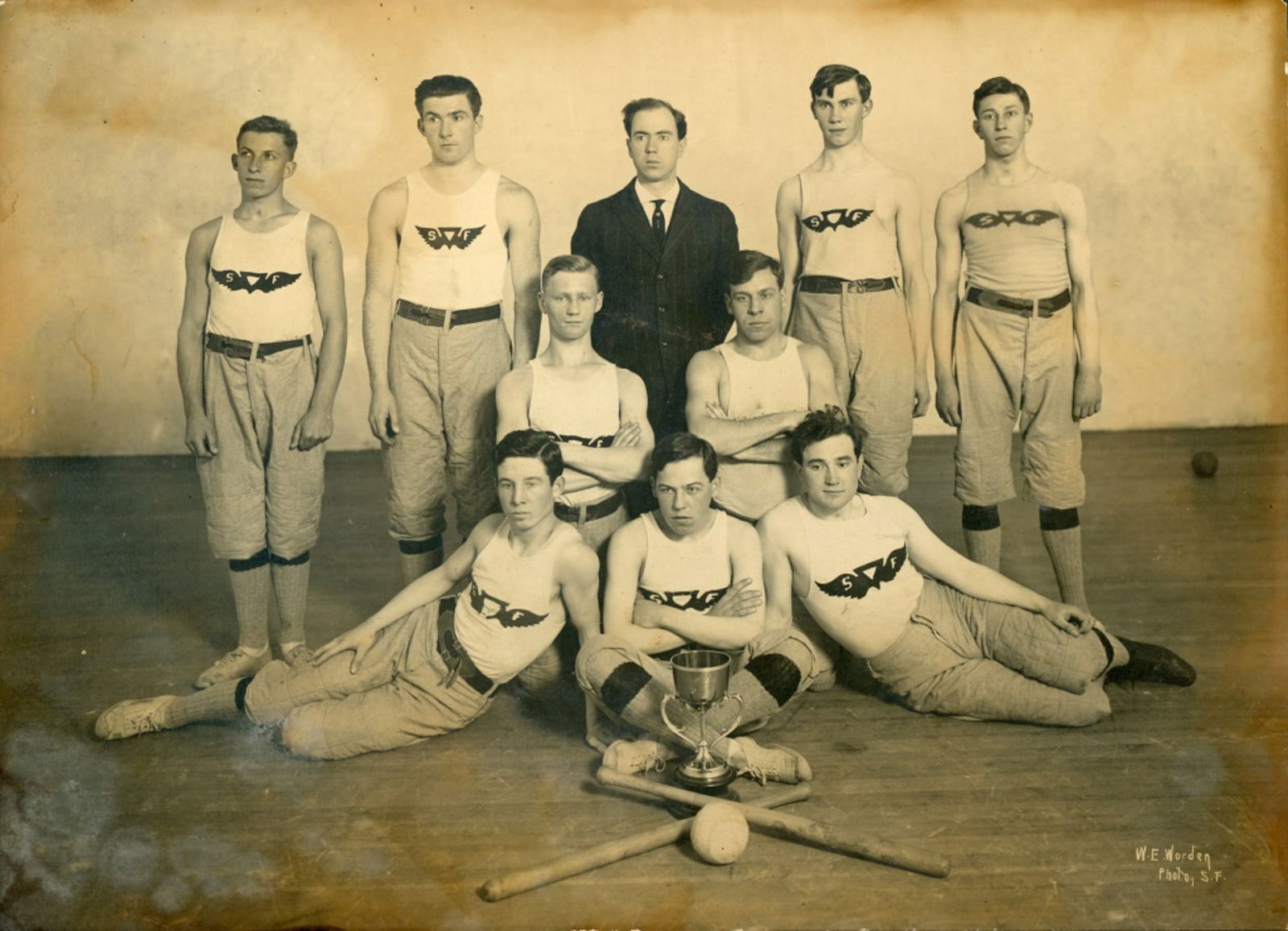 San Francisco Stickball Champions Team Photograph: San Francisco Stickball Champions Team Photograph, circa 1910-20's. Image depicts 9 man team with coach, ball, bats & trophy. Large Format W. E. Worden studio portrait on mount. Photo measures 7.25 x