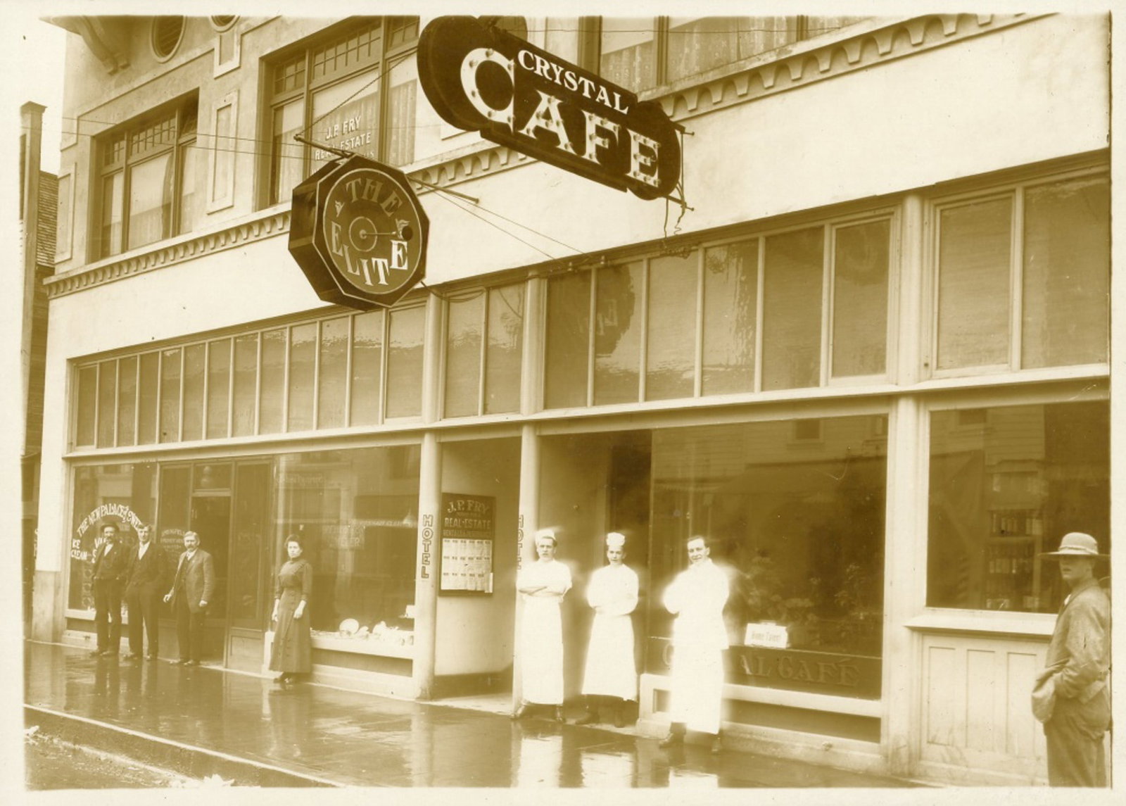 Cabinet Photo of Downtown Springfield, Oregon: Cabinet Photo of Downtown Springfield, Oregon, circa 1912. Depicts the Fry and Rankin Building (built 1911-12, 307 Main Street) with cooks out front of the Crystal Cafe and shopkeepers out front of J.