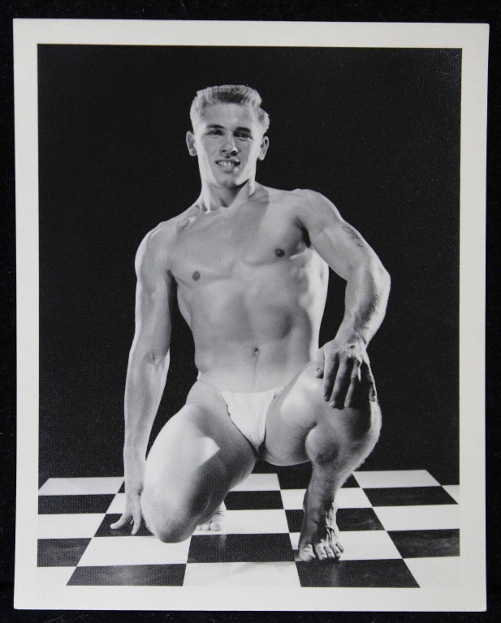 Bruce of Los Angeles Male Physique Photograph: Vintage original 4" x 5" Bruce Bellas / Bruce of Los Angeles photograph of model David Zurborg posed in studio kneeling. Stamped "Bruce 2046-7". Clear sharp image on double weight textured paper.