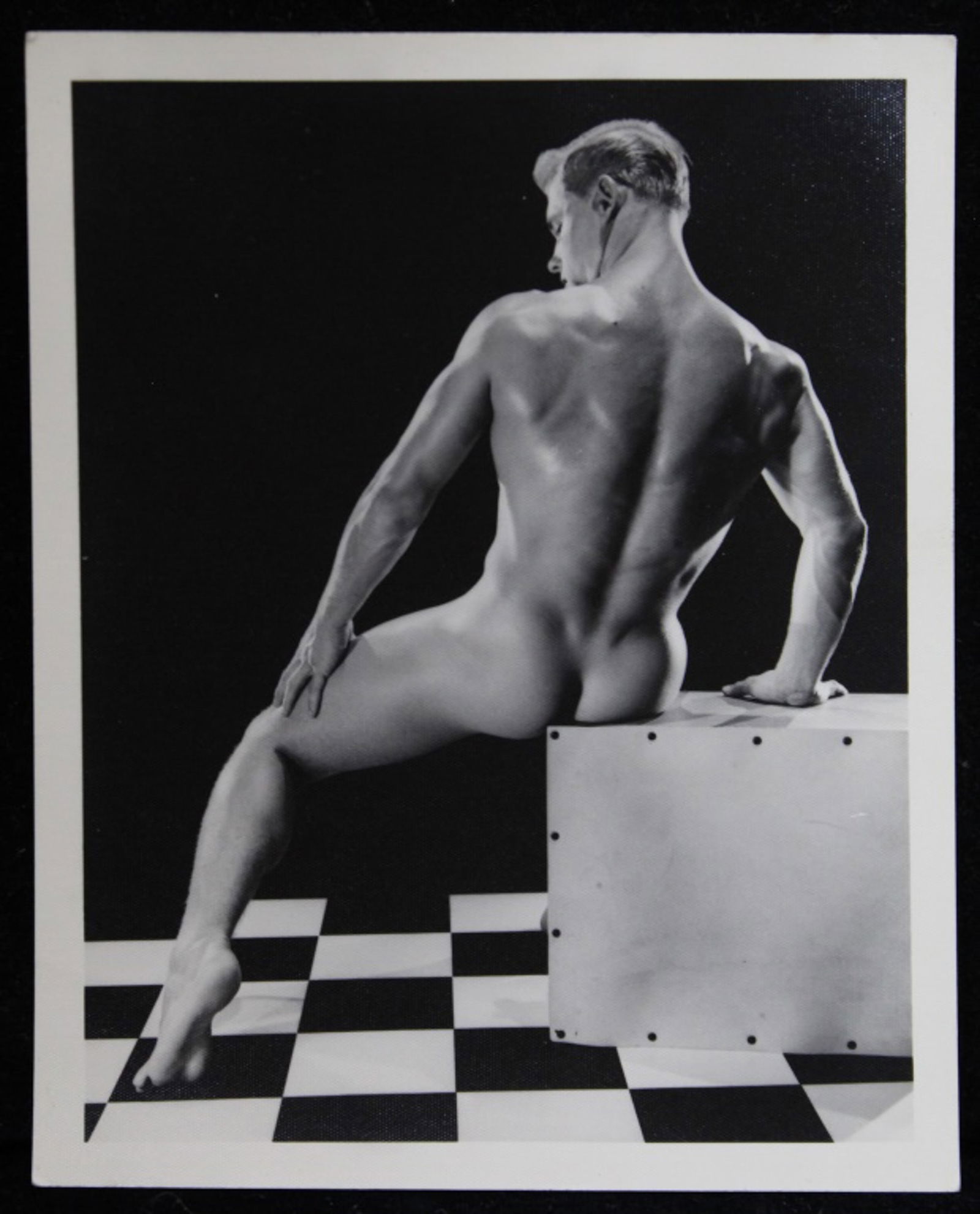 Bruce of Los Angeles Male Physique Photograph: Vintage original 4" x 5" Bruce Bellas / Bruce of Los Angeles photograph of model David Zurborg posed in studio sitting on box. Stamped "Bruce 2046-11". Clear sharp image on double weight textured pape