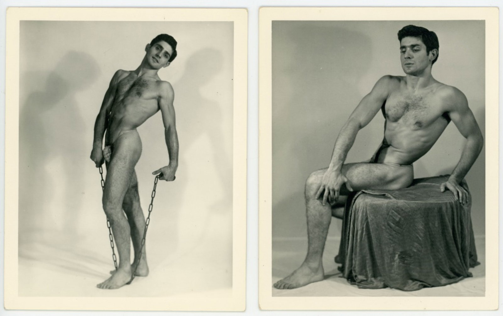 Kris Studio Male Physique Photographs: Two vintage original 4" x 5" Chuck Renslow / Kris Studio photographs of the same model posed standing with chain and posed seated on fabric draped box. Not stamped or numbered. Clear sharp images on d