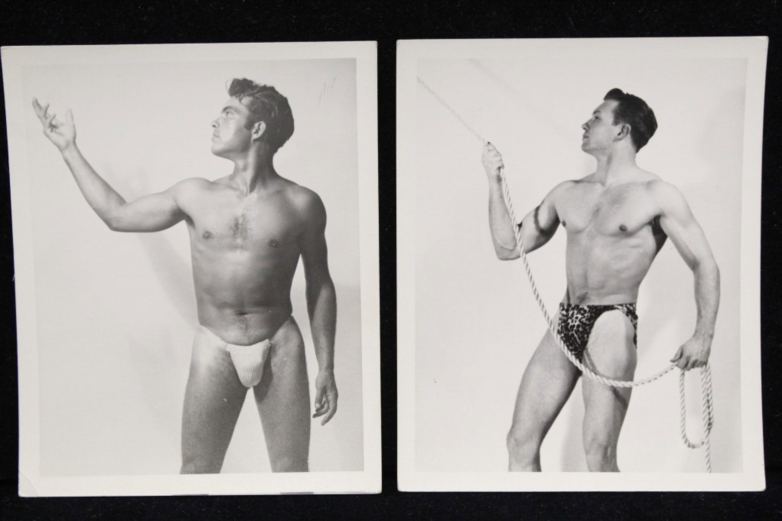Kris Studio Male Physique Photographs: Two vintage original 4" x 5" Chuck Renslow / Kris Studio photographs. (1) Model in posing strap with arm outstretched. Unstamped. (2) Model posed wearing leopard print briefs and holding rope. Unstamp