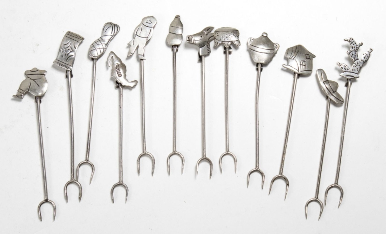 Taxco Mexico Sterling Silver Cocktail Forks: Set of 12 vintage sterling silver cocktail / hors d'oeuvre forks. Different "charm" top to each. All stamped PLATA AARON . D TAXCO along with eagle 3 marks. Good condition. 26 total grams approx. 3 1/