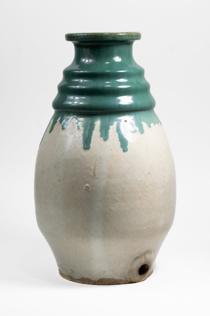Japanese Shigaraki Stoneware Sake Jar: Japanese Shigaraki stoneware sake jar. Body in cream glaze with thick green drip glaze to neck. Hole for spout at bottom. Faint inked mark to bottom. Excellent condition. 15" H. Lip 4 5/8" dia. Base 5